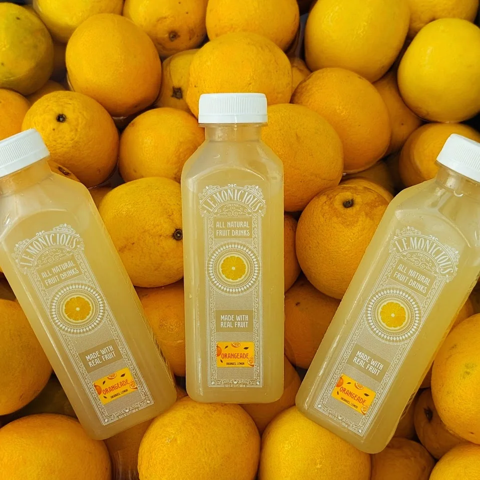 Lemonicious Orangeade bottles surrounded by fresh oranges